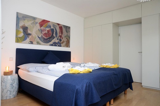 A stylish bedroom with a large bed and modern decor at Seeappartement Marina
